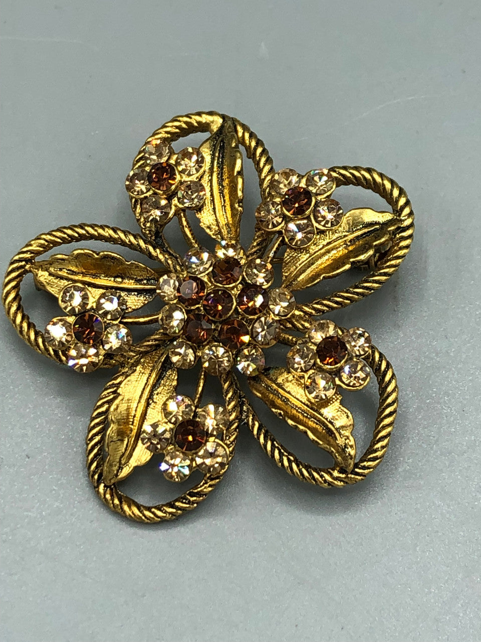 Gold tone crystal flower brooch