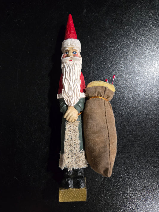 Resin Santa Claus holding big pin cushion