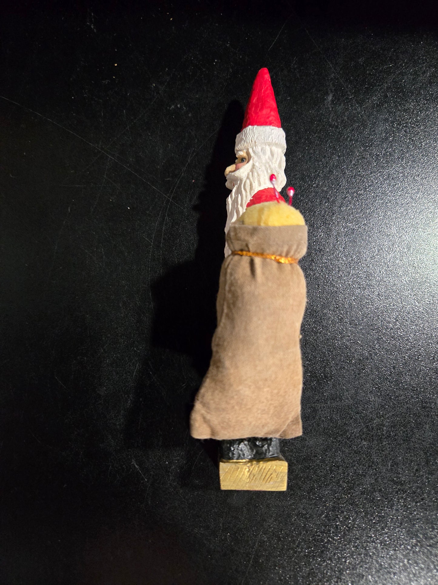 Resin Santa Claus holding big pin cushion