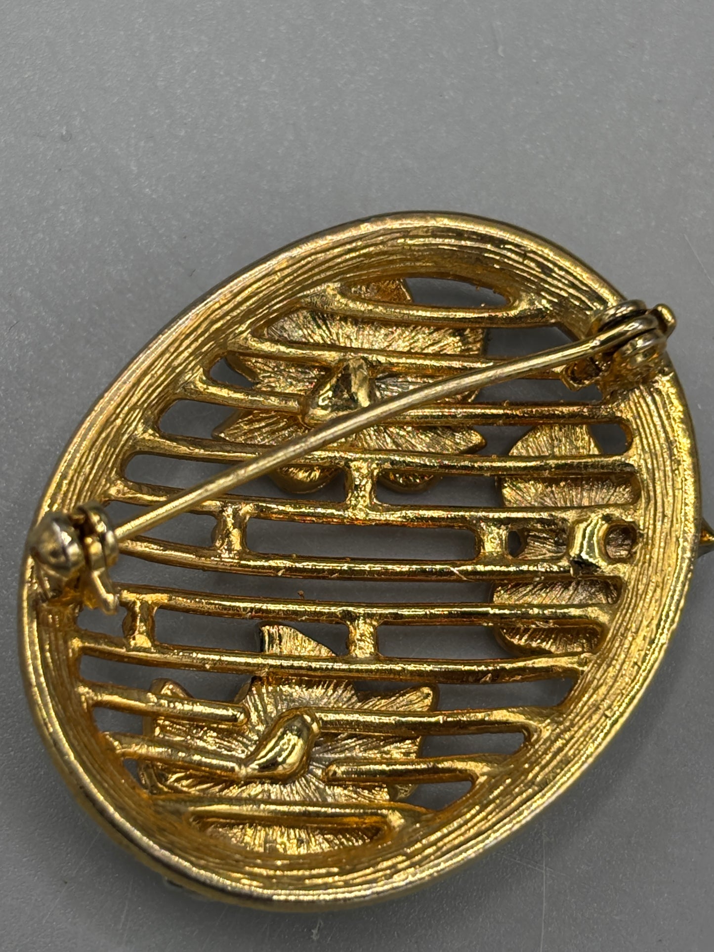 Oval gold tone brooch