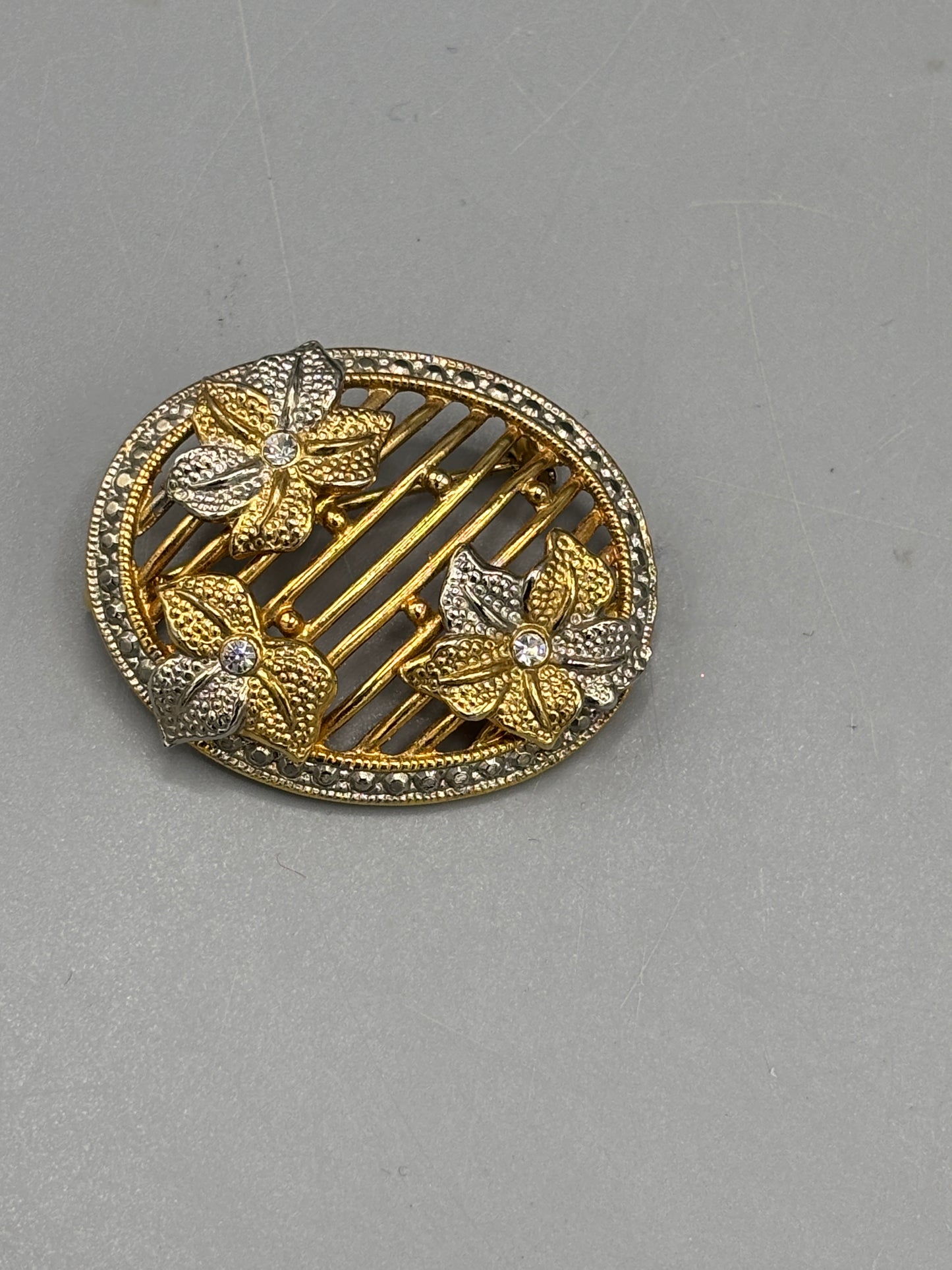 Oval gold tone brooch
