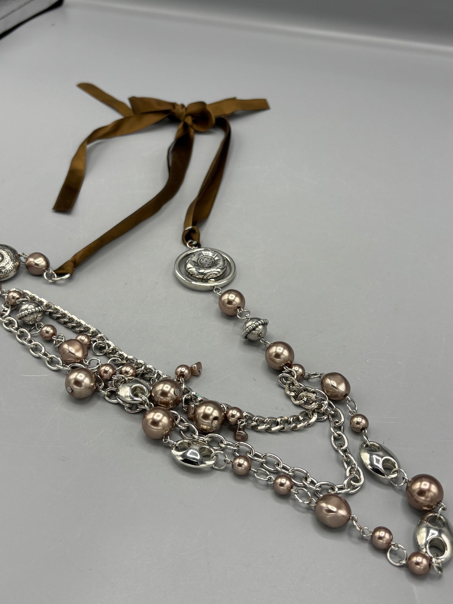 Silver beads with brown ribbon