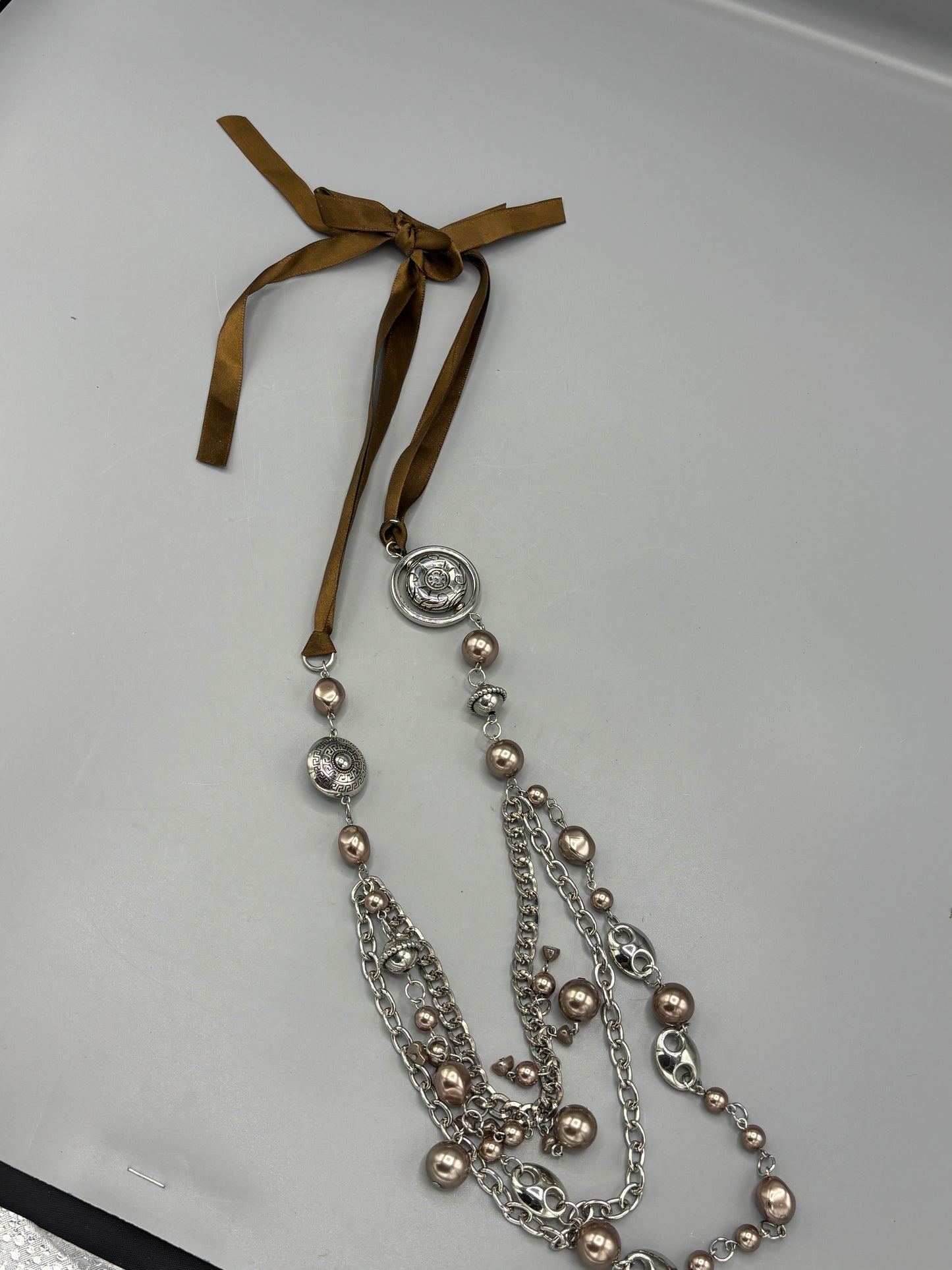 Silver beads with brown ribbon