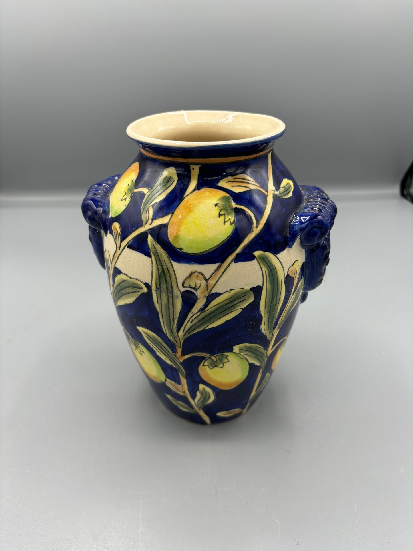 Blue glazed vase with yellow olive fruit