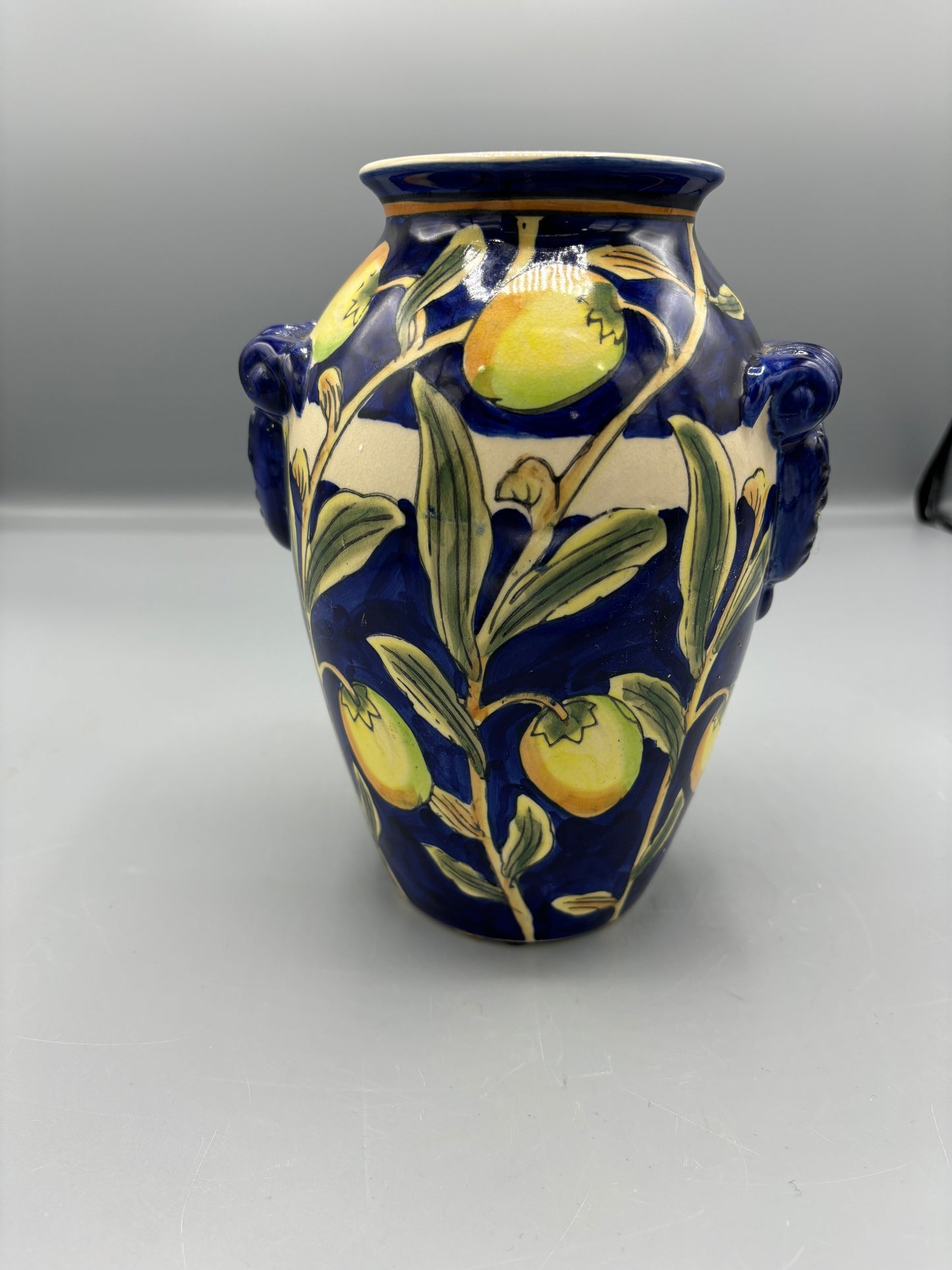 Blue glazed vase with yellow olive fruit