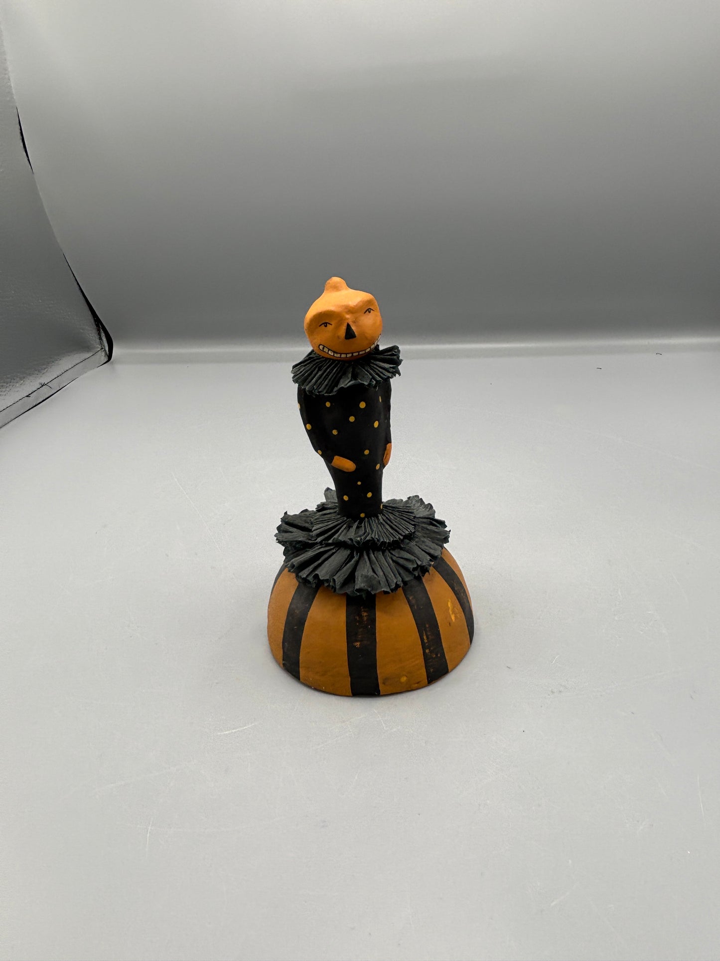 Standing Pumpkin head girl figure on striped base
