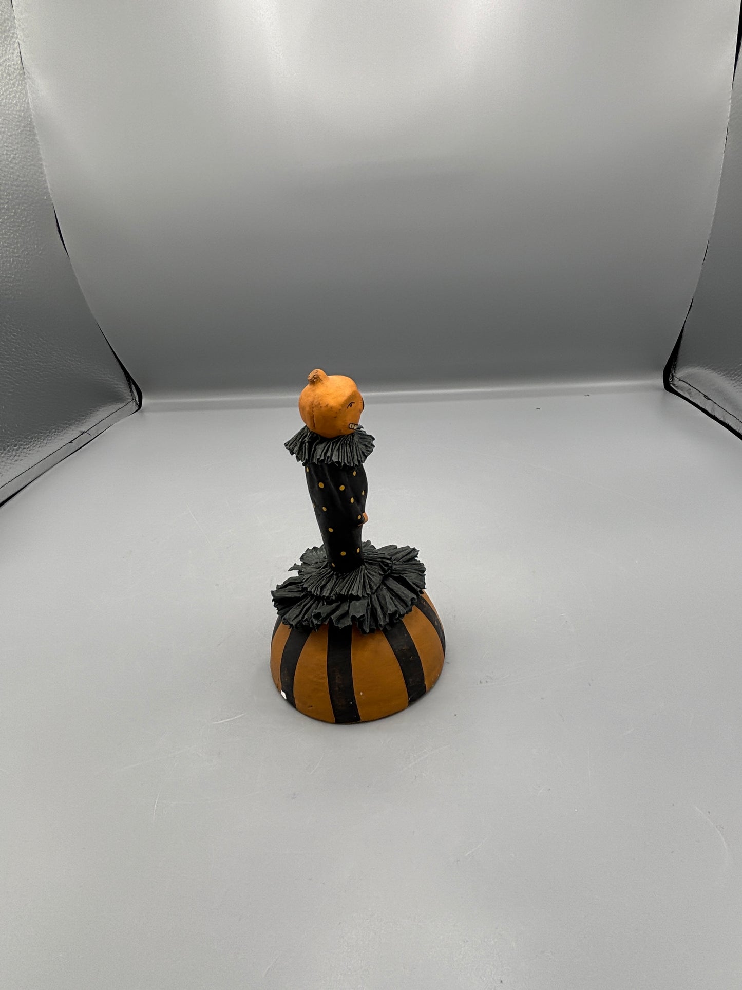 Standing Pumpkin head girl figure on striped base