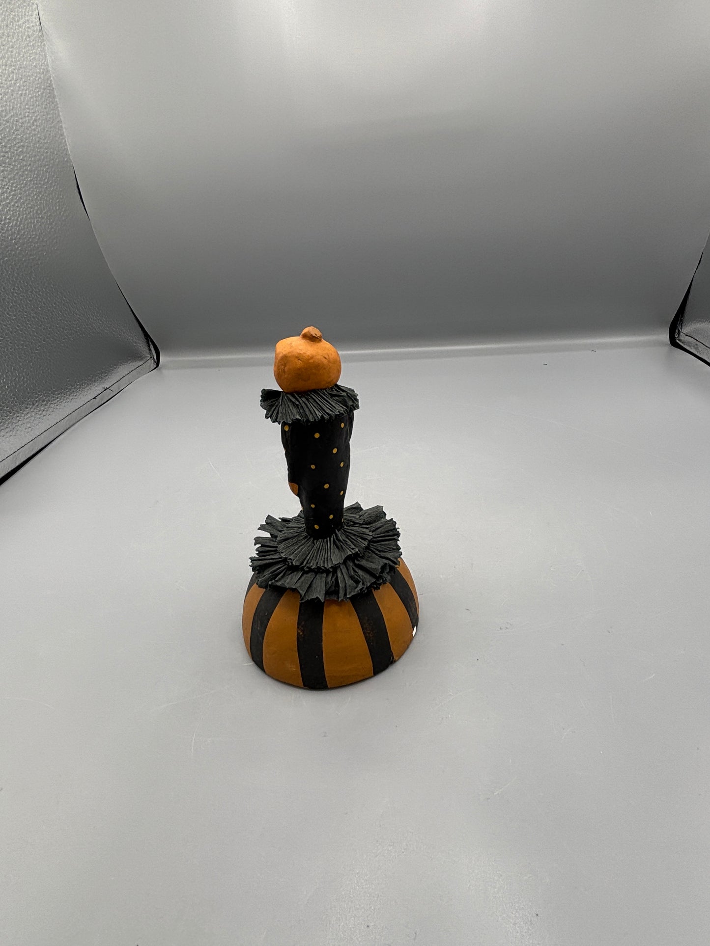 Standing Pumpkin head girl figure on striped base