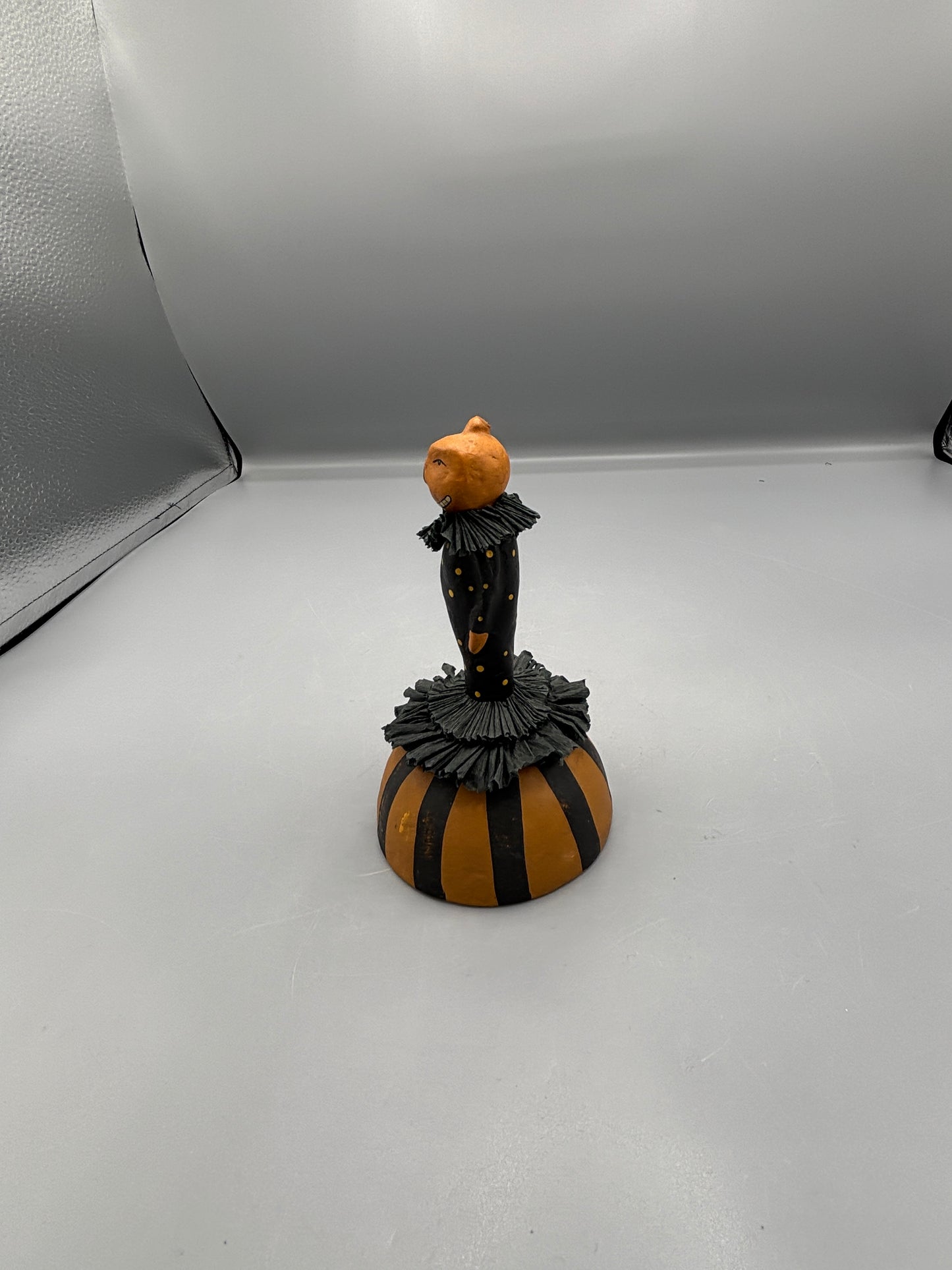 Standing Pumpkin head girl figure on striped base